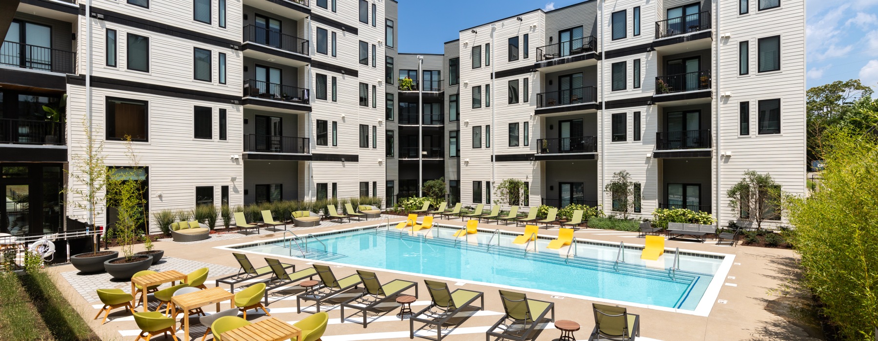 pool area with chaise lounge chairs inside apartment courtyard